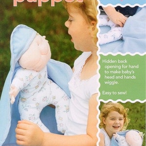 May include: A soft baby doll puppet sewing pattern with a blue and white floral print. The pattern includes instructions for making a baby doll puppet with a hidden back opening for the hand to make the baby's head and hands wiggle. The pattern is easy to sew and is available from SewBaby, Inc.