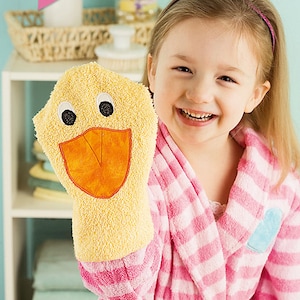 May include: A girl in a pink and white striped robe holds a yellow duck bath puppet. The puppet has a large orange beak and black eyes. The text "Sew Baby" is in a pink heart shape at the top of the image. The text "Patterns for 10 adorable animals!" is at the top right of the image. The text "Bath Puppet Pals" is at the bottom of the image.