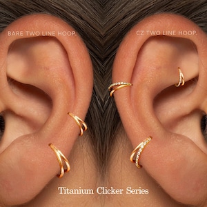 Puede incluir: Primer plano de orejas adornadas con pendientes de clicker de titanio dorados. La imagen muestra dos estilos: un aro de dos líneas liso y un aro CZ de dos líneas, cada uno con un diseño distintivo. El texto "Titanium Clicker Series" es visible.