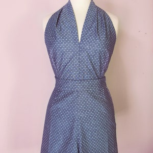 May include: A blue and white polka dot halter top and shorts set. The top has a deep V-neckline and the shorts have a high waist.