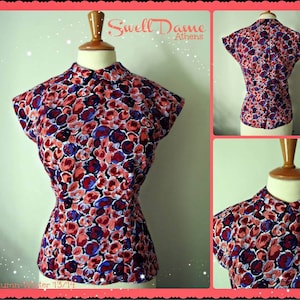 May include: A red, blue, and white floral print blouse with a mandarin collar. The blouse has a fitted bodice and a slightly flared skirt. The text "Swell Dame Athens" is visible in the top right corner of the image.