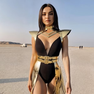 May include: A black bodysuit with a plunging neckline, paired with gold-colored shoulder armor, a belt, and a skirt-like accent. The outfit is worn in an outdoor setting with a desert landscape.