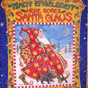 May include: A Christmas book cover featuring a red and gold illustration of Santa Claus with a white beard, wearing a red and gold robe with stars and carrying a staff. He is walking with a black and white dog in a snowy winter scene. The title of the book is "Christmas with Mary Engelbreit Here Comes Santa Claus".