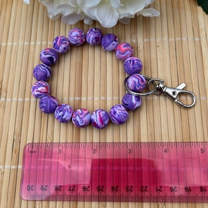Purple/pink swirl option is pictured with a ruler to illustrate the chunky size of the handmade polymer clay beads.