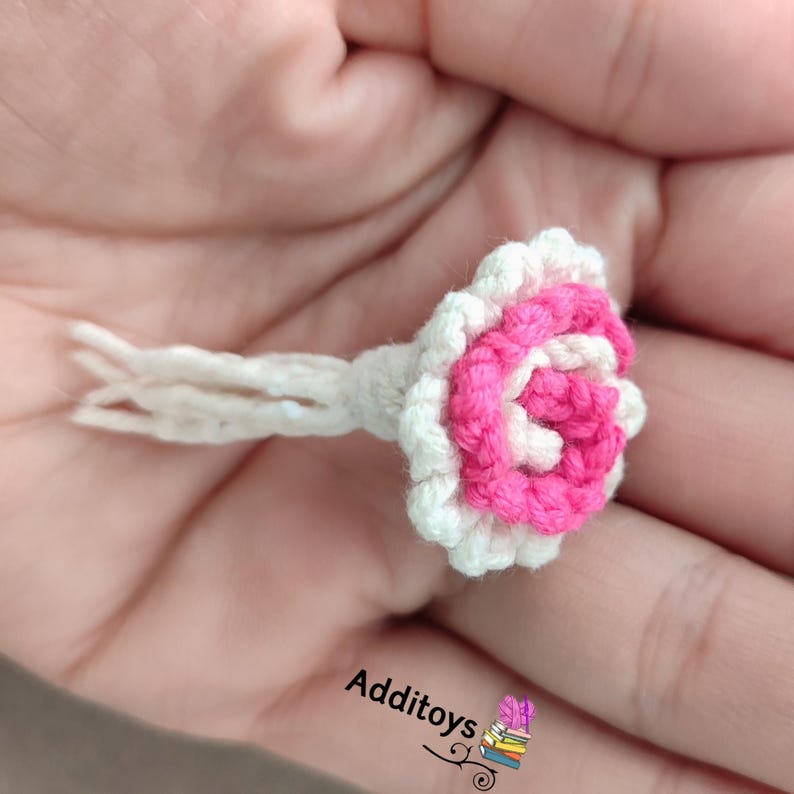 Peut inclure: Une petite fleur crochet&eacute; blanche et rose avec une longue tige blanche.