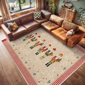 Puede incluir: Una alfombra beige y crema con un borde rojo y blanco. La alfombra presenta un patrón repetitivo de figuras de cascanueces navideños en varias poses. La alfombra está colocada sobre un suelo de madera en un salón.