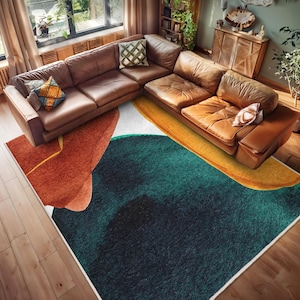 May include: A contemporary area rug with an abstract design. The rug incorporates rust, teal, yellow, and white in flowing, organic shapes. A brown leather sectional sofa is positioned above the rug, complementing the colour scheme.