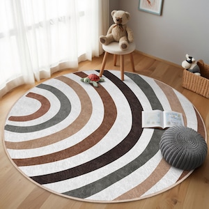 May include: A round, multi-colored rug with a striped pattern in shades of brown, gray, and white. The rug has a circular shape and is made of soft, plush material.