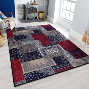 Può includere: Un tappeto multi-colore con un design a patchwork che presenta tonalità di rosso, blu e beige. Il tappeto ha un motivo paisley ed è realizzato in un materiale morbido e resistente.