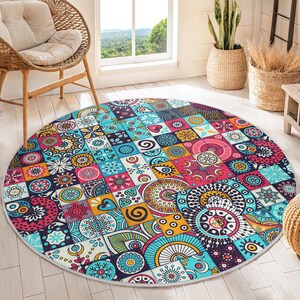 May include: A round, colorful rug with a patchwork design featuring various geometric shapes and patterns in shades of blue, red, yellow, and white.
