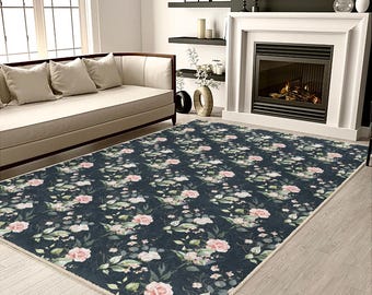 Può includere: Un tappeto blu scuro con un motivo floreale con fiori rosa e foglie verdi. Il tappeto si trova in un soggiorno con un divano e un camino.