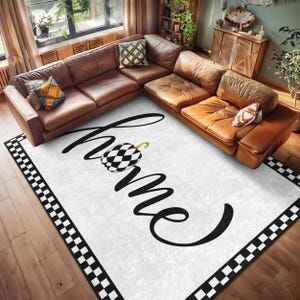 May include: White and black checkered border rug with the word "home" in black script with a black and white checkered pumpkin in the center.