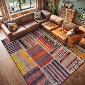 Könnte beinhalten: Ein mehrfarbiger Patchwork-Teppich mit verschiedenen geometrischen Mustern in Rot-, Orange-, Gelb-, Blau- und Schwarztönen. Der Teppich liegt auf einem Holzboden vor einem braunen Ledersofa.