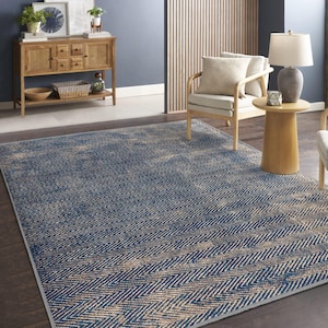 May include: A blue and beige area rug with a chevron pattern. The rug is in a living room setting with a wooden chair and a side table.