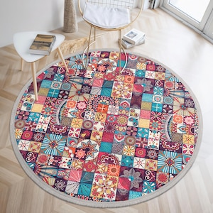 Puede incluir: Una alfombra redonda multicolor con un diseño de patchwork que presenta varias formas geométricas y patrones florales. La alfombra tiene un borde gris claro.
