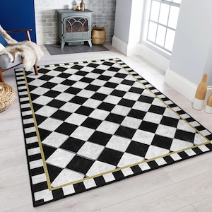 Könnte beinhalten: Schwarz-weiß karierter Teppich mit gold-schwarzem Rand. Der Teppich hat ein Rautenmuster und ist aus einem weichen, strapazierfähigen Material gefertigt.