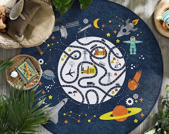 May include: A round, navy blue rug with a white center featuring a road map design. The rug has illustrations of planets, rockets, stars, and an astronaut. The rug is surrounded by plants and wicker furniture.