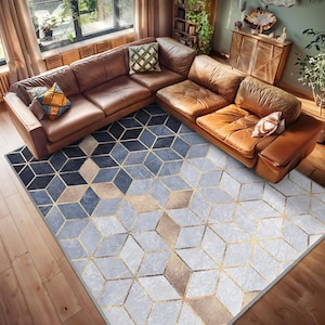 May include: A geometric patterned rug with blue, gold, and brown colors. The rug is laid out on a wooden floor in a living room with a brown leather sectional sofa.