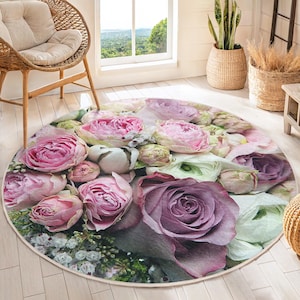 Puede incluir: Una alfombra redonda floral con un diseño de flores rosas, moradas y blancas. La alfombra presenta una variedad de flores, incluyendo rosas, peonías y lirios.
