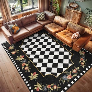 Puede incluir: Alfombra a cuadros en blanco y negro con un borde floral. La alfombra tiene un ribete dorado y se coloca sobre un suelo de madera en un salón.