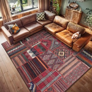 May include: A large, multi-colored patchwork rug with a variety of geometric patterns in shades of red, blue, green, and brown. The rug is laid out on a wooden floor in a living room setting, with a brown leather sectional sofa in the background.