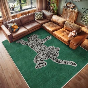 Puede incluir: Una alfombra verde con un diseño de estampado de leopardo blanco. La alfombra está en una sala de estar con un sofá seccional de cuero marrón.