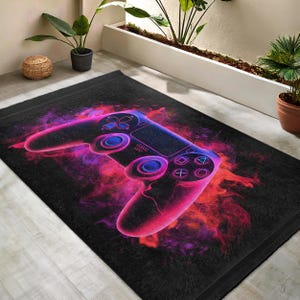 Pode incluir: Um tapete preto com um design abstrato rosa e laranja que apresenta um controlador de videogame azul brilhante.