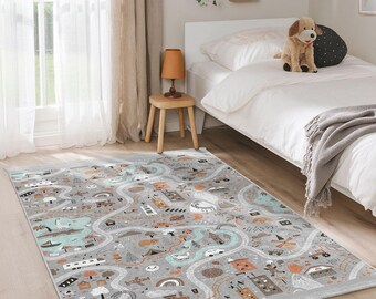 May include: A gray and white play rug with a whimsical design featuring a winding road, houses, trees, and vehicles. The rug is laid out on a light gray floor in a room with a white bed and a wooden side table.
