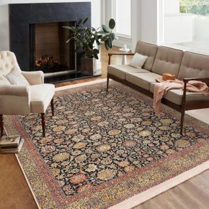 Peut inclure: Un tapis à motifs noirs et crème avec un design floral. Le tapis est posé dans un salon avec une cheminée et un canapé.