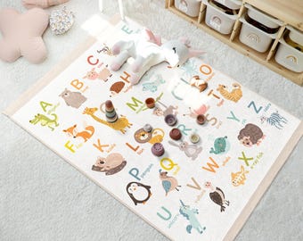 Op de afbeelding: Een kleurrijke alfabet speelmat met illustraties van dieren voor elke letter. De mat heeft een witte achtergrond met kleurrijke illustraties van dieren en letters. De letters zijn in een vet, zwart lettertype. De dieren zijn geïllustreerd in een cartoon stijl.