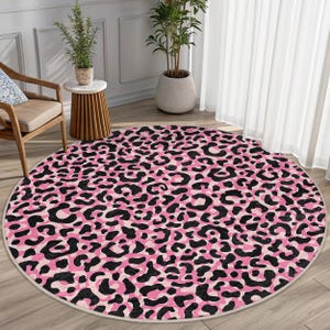 May include: A pink and black round rug with a leopard print pattern.
