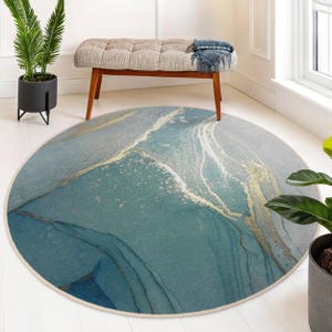May include: A round blue and gold area rug with a marbleized pattern. The rug has a white border.