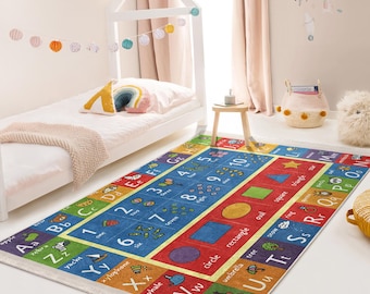 Pode incluir: Um tapete de jogo colorido com o alfabeto e os números, em tons de vermelho, azul, amarelo e verde. O tapete apresenta letras, números e imagens de objetos que começam com cada letra. O tapete é perfeito para crianças que aprendem o alfabeto e os números.