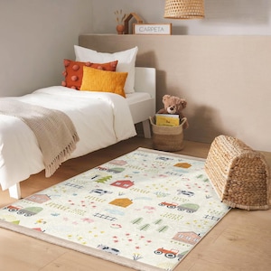 May include: A white and cream rug with a farm theme. The rug features illustrations of houses, tractors, animals, and fences. The rug is on a wooden floor in a bedroom with a white bed and a teddy bear.