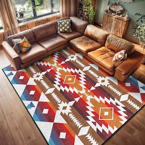 May include: A colorful geometric rug with a white background and brown, red, orange, and blue accents. The rug has a tribal pattern and is laid out on a wooden floor in front of a brown leather sofa.