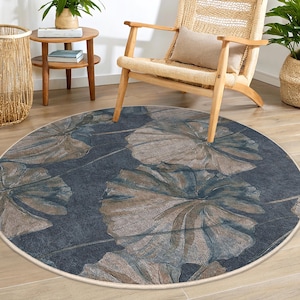 May include: A round, blue and brown area rug with a floral pattern. The rug has a cream-colored border.