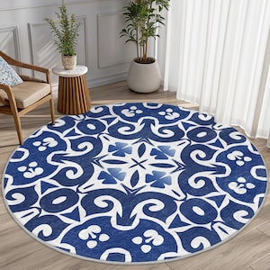 May include: A round blue and white patterned rug with a geometric design. The rug has a white background with blue swirls and floral patterns.