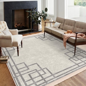 Op de afbeelding: Een rechthoekig vloerkleed met een crèmekleurige achtergrond en een geometrische grijze rand. Het vloerkleed heeft een herhalend patroon van met elkaar verbonden vierkanten en rechthoeken, wat een moderne touch geeft aan de woonkamer. Afmetingen in centimeters.