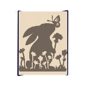 May include: A laser cut wooden wall decor featuring a silhouette of a rabbit with a butterfly on its back, surrounded by flowers. The design is in black and white.