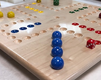 May include: A wooden board game with a light wood finish. The game board has circular indentations and coloured spaces in yellow, blue, green, and red. Blue game pieces are lined up, and a red die with white dots is visible.