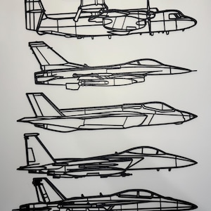 May include: Black line art of five different aircraft. The top aircraft has a large radar dome. The other four are fighter jets. All are depicted in profile against a white background.