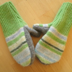 May include: A pair of green and white striped knitted mittens with gray cuffs. The mittens are made of a soft, fuzzy yarn.