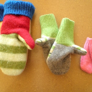May include: Four pairs of knitted mittens in various colors and patterns. The mittens are made of wool and have a soft, cozy texture. The colors include green, red, blue, gray, and pink.