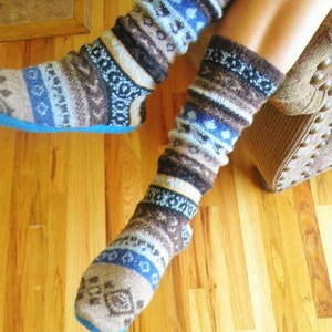 May include: A pair of cozy socks with a blue, brown, and white patterned design. The socks are made of a soft, warm material and are perfect for keeping your feet warm in the winter.