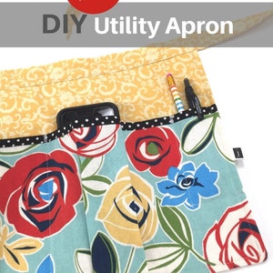 May include: A DIY utility apron with a floral print featuring red, yellow, and blue roses on a light blue background. The apron has multiple pockets, including a large pocket for a phone and smaller pockets for pens and pencils. The apron is made from fabric with a yellow floral pattern.