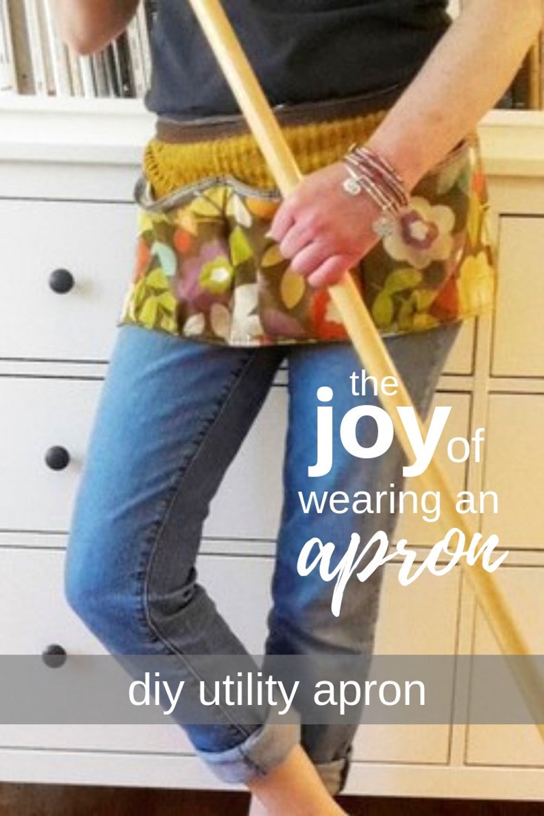 May include: A woman wearing a colorful utility apron with pockets and a brown belt. She is holding a wooden broom and the text "the joy of wearing an apron" and "diy utility apron" is visible.