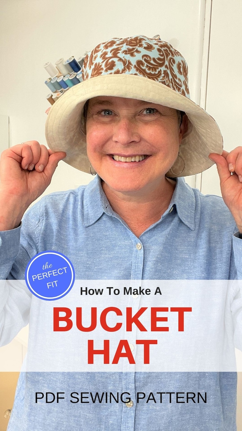 May include: A woman wearing a blue shirt holds up a brown and blue bucket hat with a white brim. The hat has a paisley pattern. The text "the PERFECT FIT" and "How To Make A BUCKET HAT PDF SEWING PATTERN" is displayed below the image.