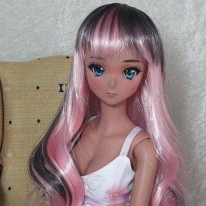 May include: A doll with long pink and black hair, blue eyes, and freckles. She is wearing a white dress with a floral pattern and a pink sash.