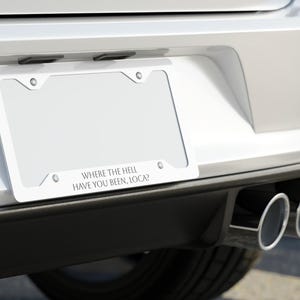 以下が含まれることがあります： 銀色の車に「WHERE THE HELL HAVE YOU BEEN, LOCA?」という文字が書かれた白いナンバープレートフレーム