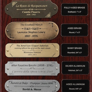 May include: A display board featuring five metal nameplates with various finishes and shapes, including brass and aluminum. Each plate displays artist names, titles, and dates. To the right, five black labels identify the material and dimensions in inches.